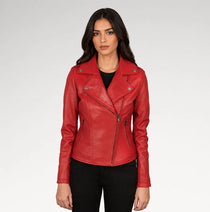 A woman modeling a red faux leather moto jacket with silver-tone hardware, worn over a black top and black pants, against a light gray studio background.