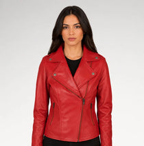 A woman modeling a bright red faux leather moto jacket with an asymmetrical zipper, set against a plain light gray studio background.