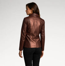A woman shown from the back wearing a metallic bronze-brown leather jacket and black pants, photographed against a clean light gray studio background.
