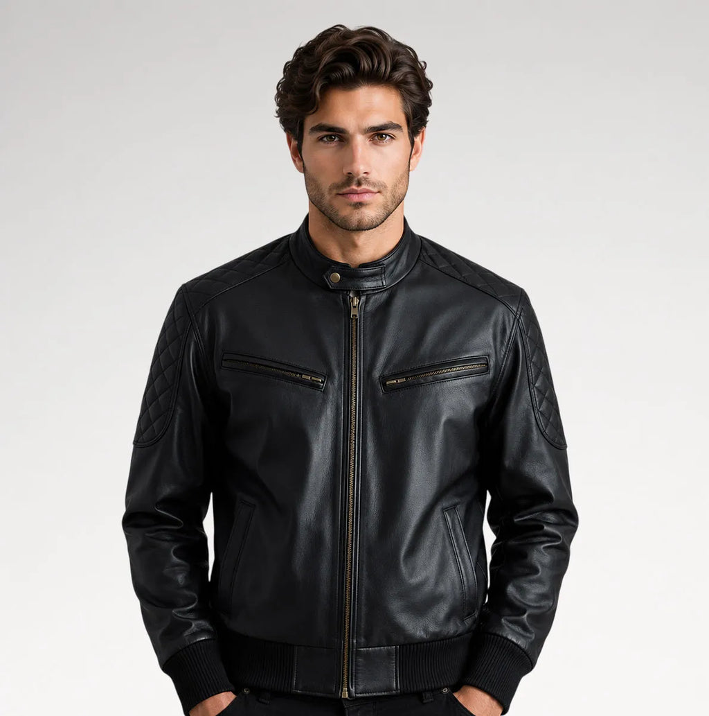 A man wearing a black leather jacket with a stand collar, front zipper, and zippered chest pockets, photographed against a light gray studio background.