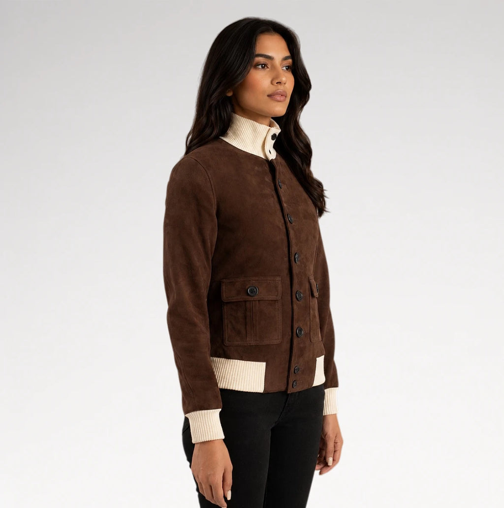 A woman modeling a brown suede button-up cardigan with cream ribbed trim, worn over a cream mock-neck top and black pants, against a light gray studio background.