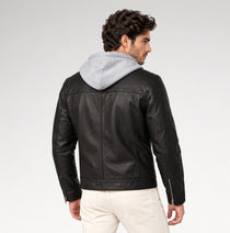 A man wearing a black faux-leather moto jacket with a light gray hood, shown from the back against a light gray studio background.