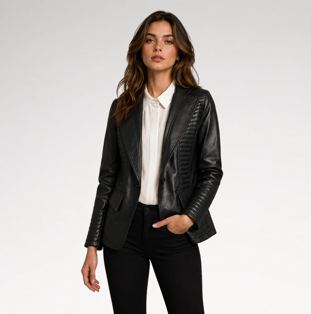 A woman modeling a black faux-leather blazer with quilted vertical detailing on the lapels and sleeves, styled over a white collared shirt and black pants against a light gray studio background. Main image