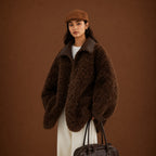 Person wearing a brown fluffy coat and hat against a brown background