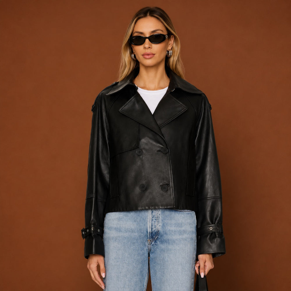 Woman wearing a black leather jacket and blue jeans against a brown background