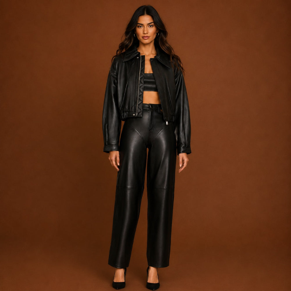 Woman wearing a black leather jacket and pants on a brown background