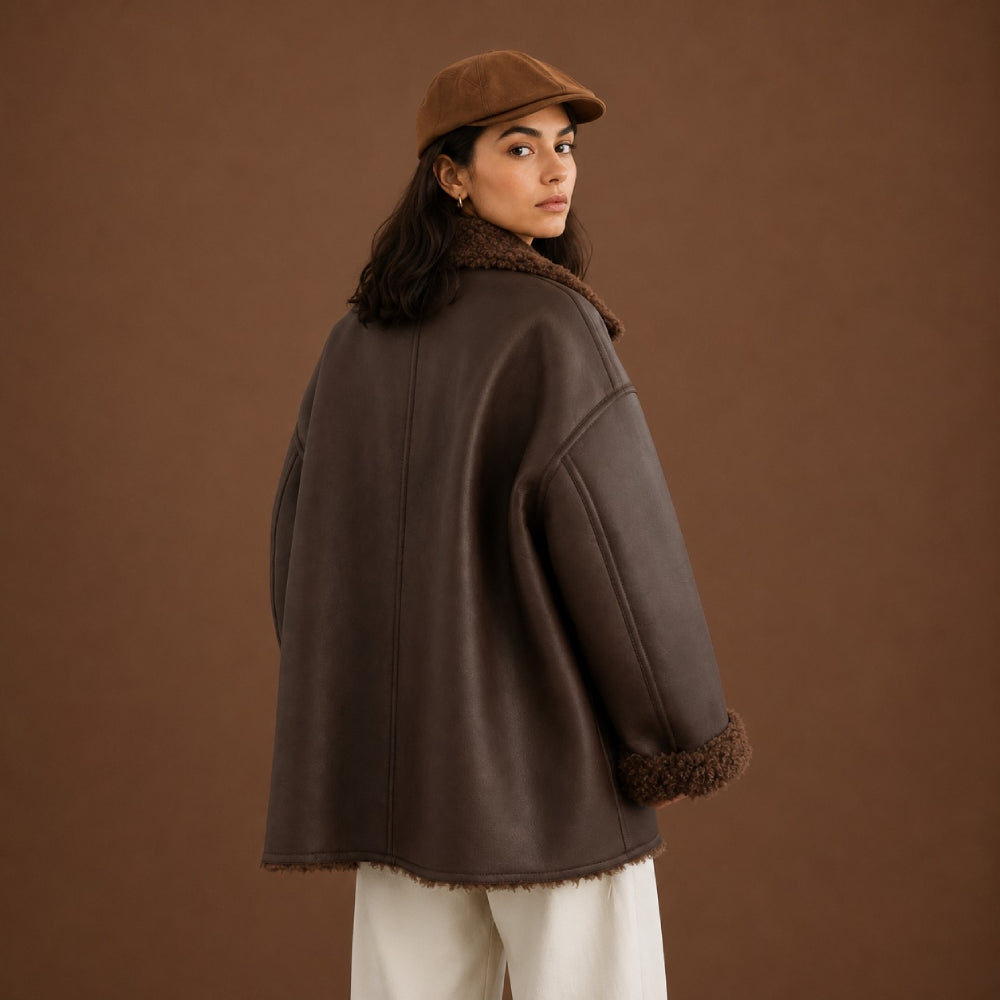 Person wearing a brown coat with fur trim against a brown background