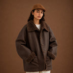 Person wearing a brown shearling jacket and hat against a brown background