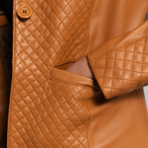 Close-up of a brown quilted leather jacket with a button.