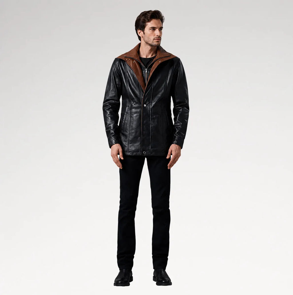 A man modeling a black leather jacket with a brown suede-like hood, paired with black jeans and black boots, against a light gray studio background.