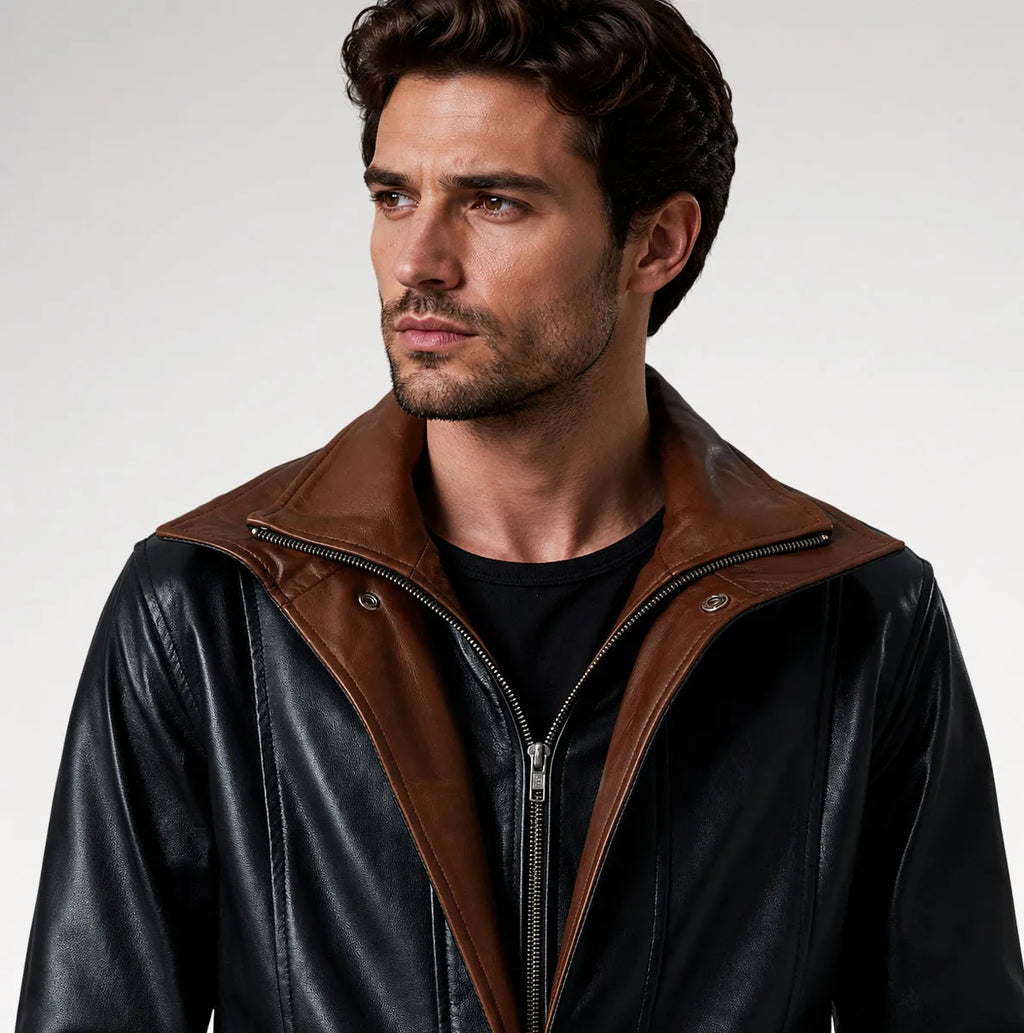 A man wearing a black leather jacket with a contrasting brown collar and zipper trim, photographed against a light gray studio background.