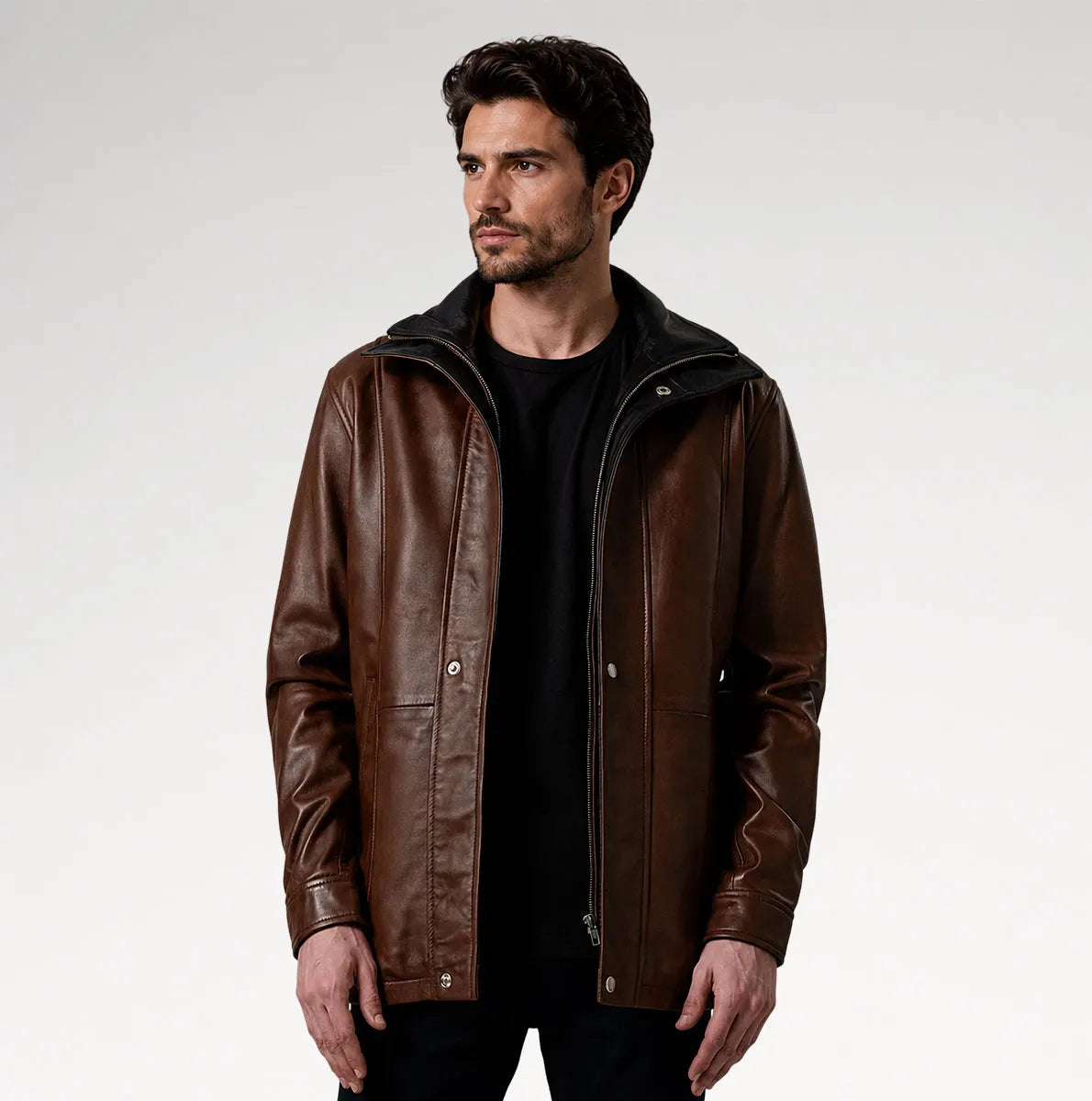 A man wearing a brown leather jacket with a black hood, layered over a black t-shirt, photographed against a neutral light gray studio background. Main image