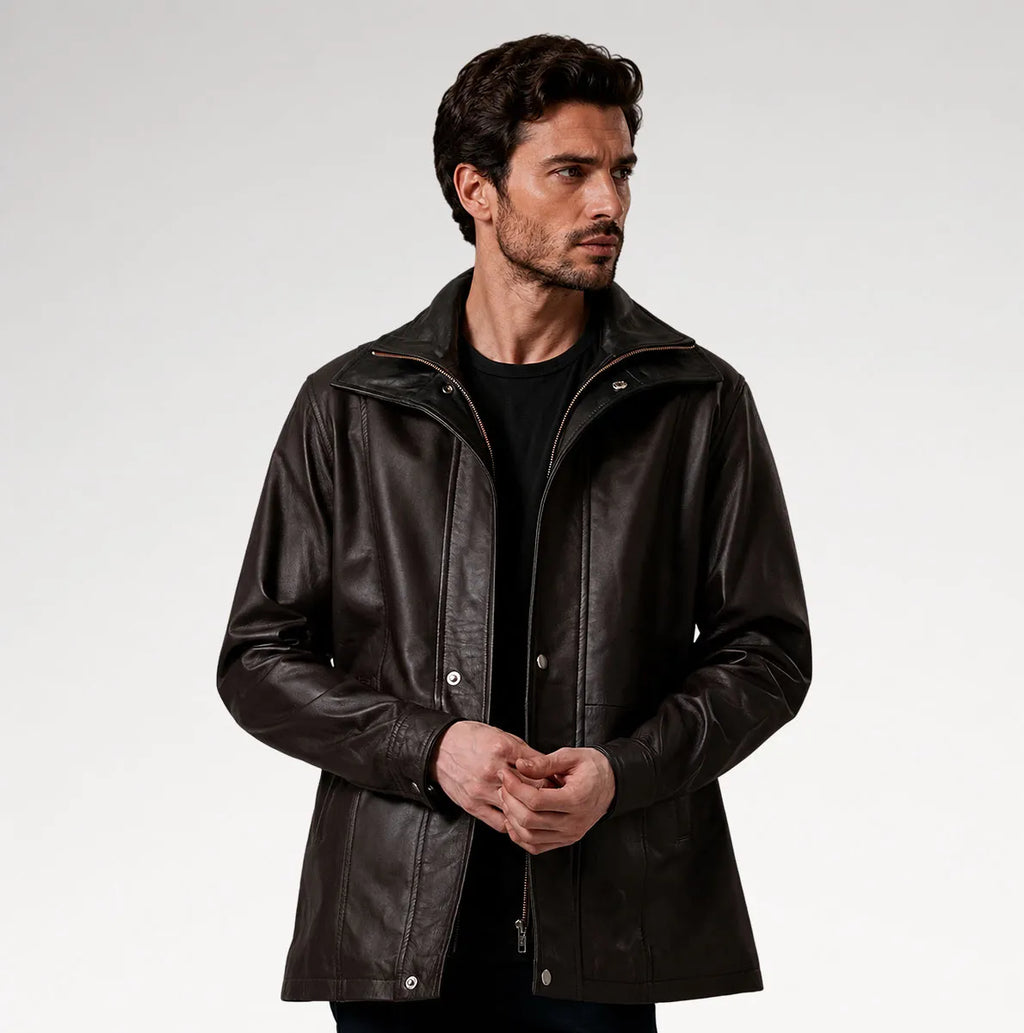 A man wearing a dark brown leather jacket over a black shirt, photographed against a light gray studio background.