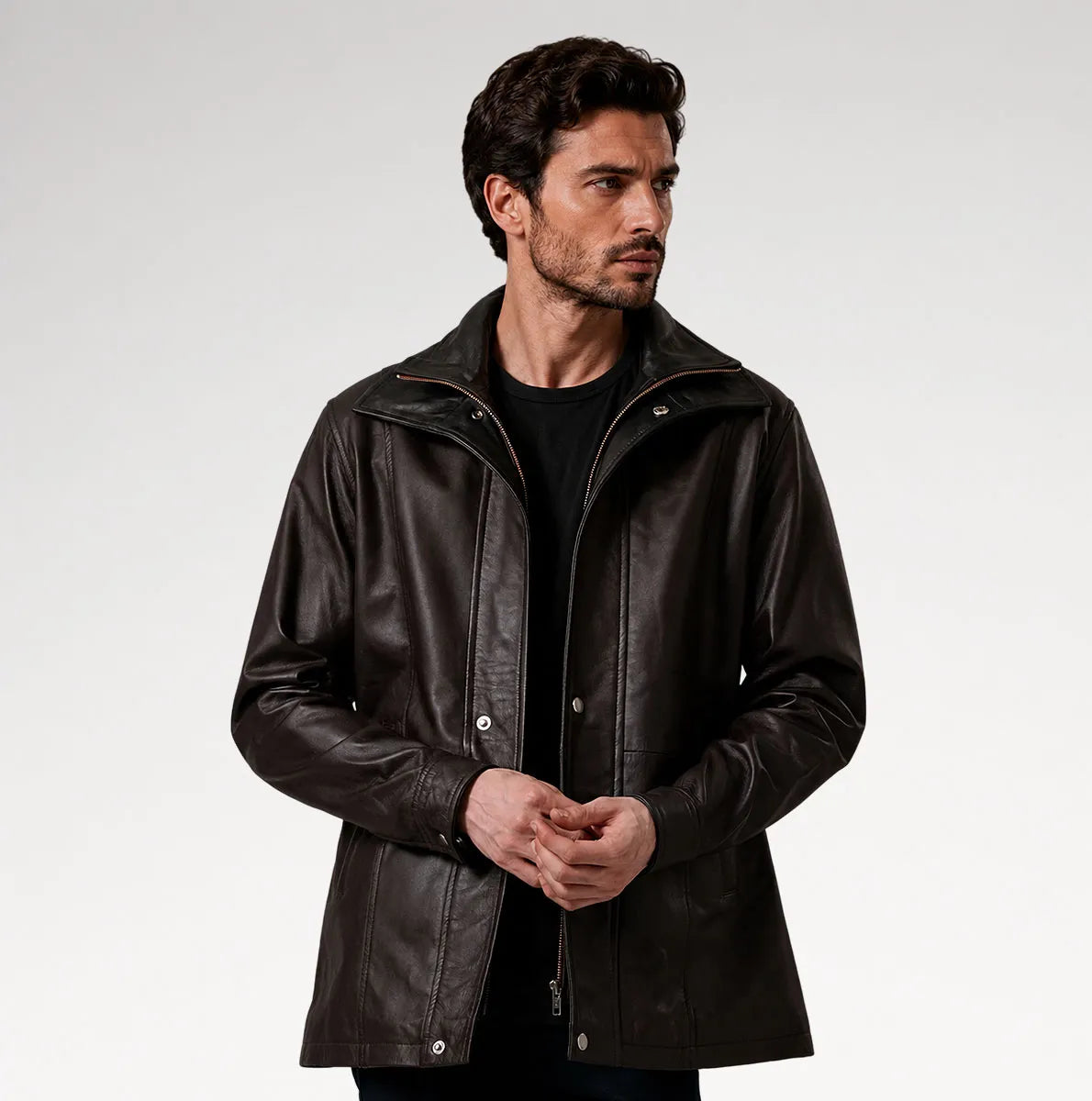 A man wearing a dark brown leather jacket over a black shirt, photographed against a light gray studio background. Main image