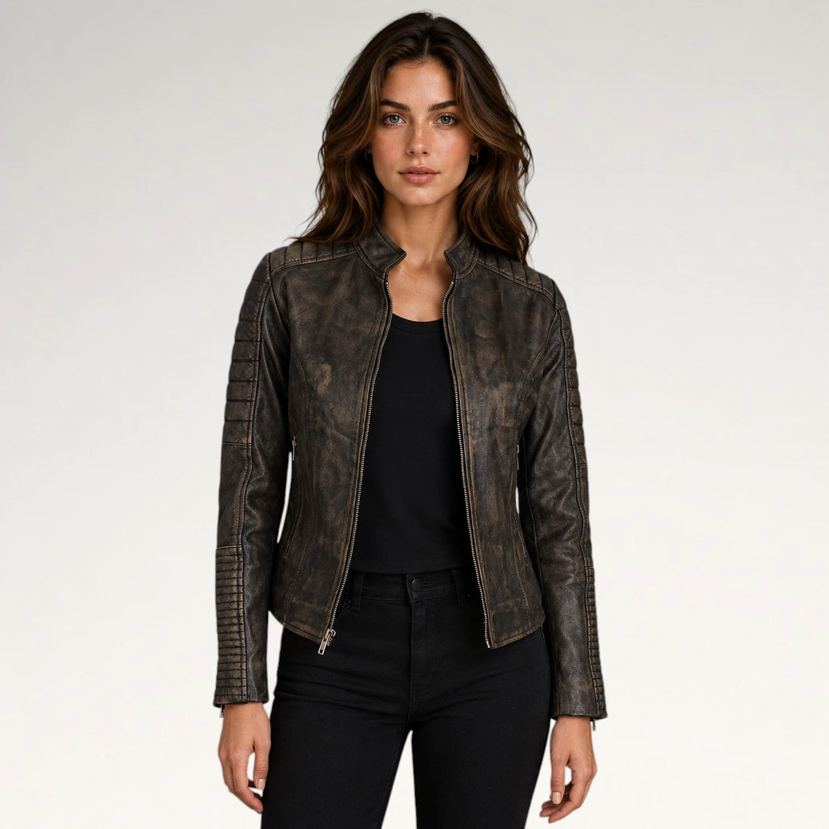 A woman modeling a distressed dark brown faux leather moto jacket with silver zippers, worn over a black top and black jeans, against a plain light gray background. Main image